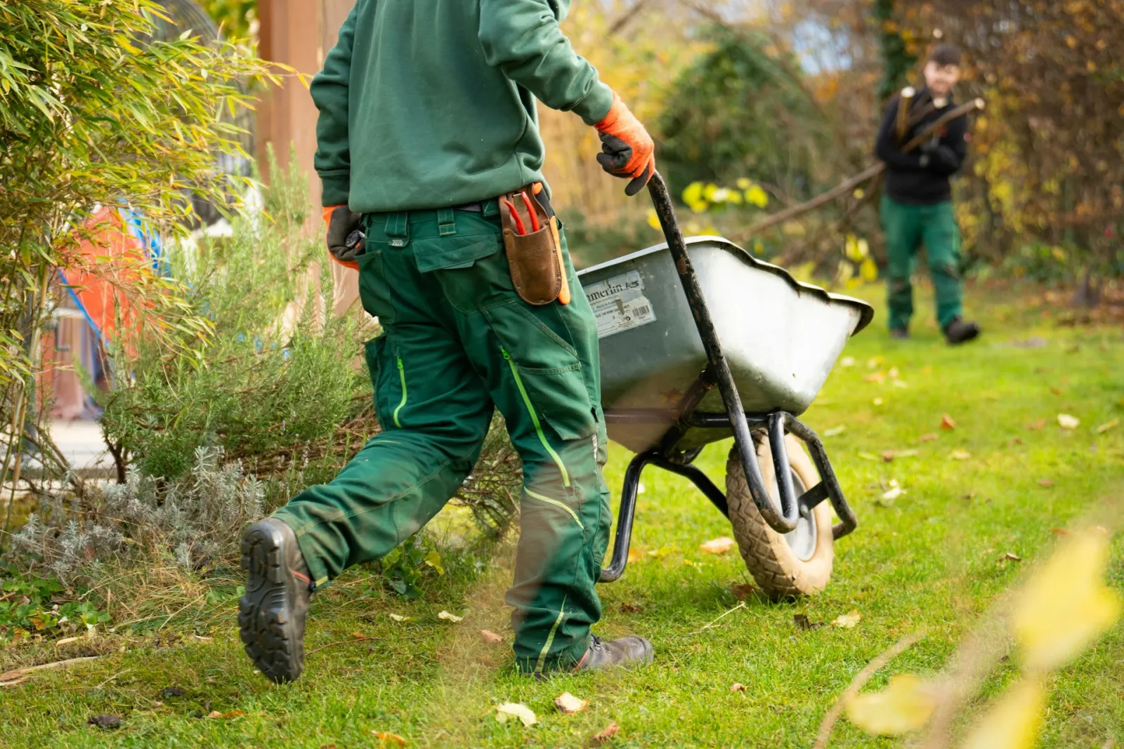Landscapers moving materials through a garden worksite