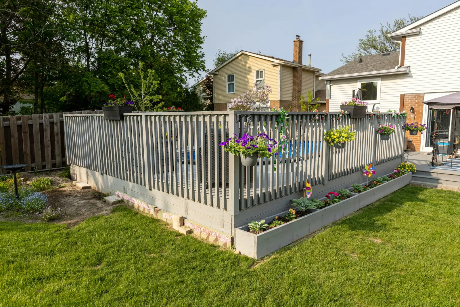 A glass pool fence beside a landscaped swimming pool